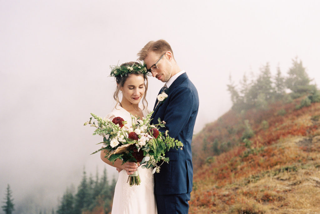 bride and groom embrace in fog